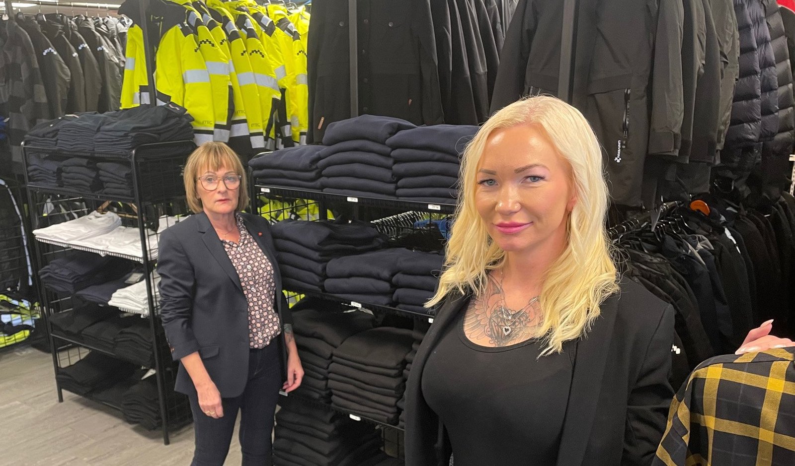 Annelen Strømsnes og Nita i Norep-butikken i Bodø, omgitt av arbeidsklær fra hyllene.